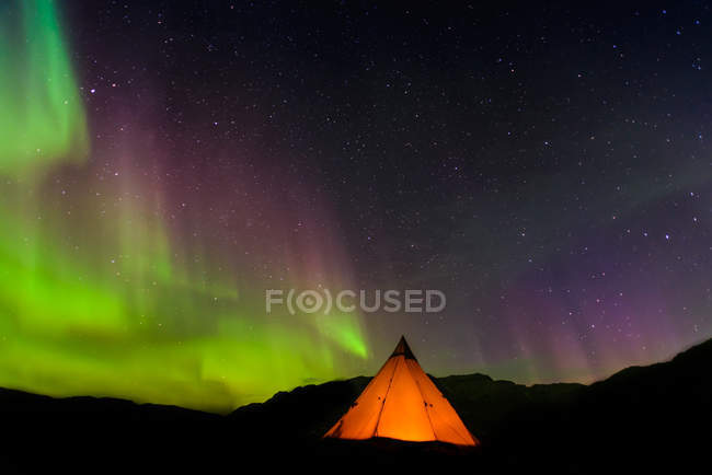 Tente lumineuse et aurore boréale en arrière-plan, Narsaq, Vestgronland, Groenland — Photo de stock