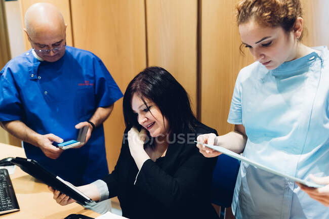 Zahnärztin und Zahnpflegerin mit Patient, Blick auf digitales Tablet — Stockfoto