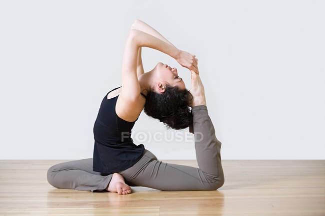 Side view of young woman stretching — Stock Photo