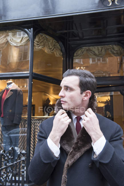 Cliente masculino em casaco de inverno perto de loja de alfaiate — Fotografia de Stock
