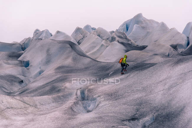 Senderismo masculino sobre el paisaje cubierto de nieve gris, Narsaq, Vestgronland, Groenlandia del Sur - foto de stock