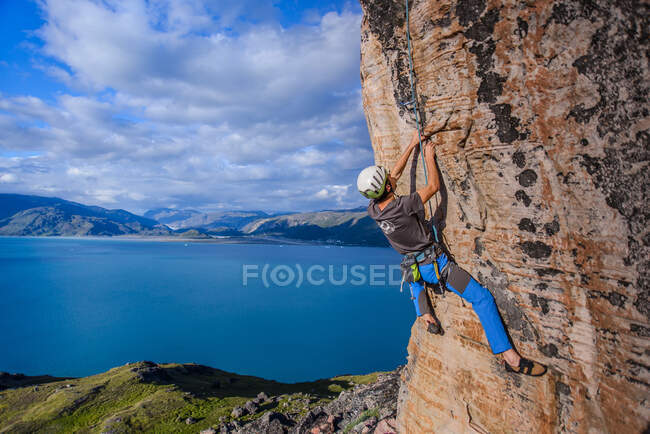 Giovane arrampicatore maschile parete rocciosa in arenaria, Narsaq, Vestgronland, Groenlandia meridionale — Foto stock