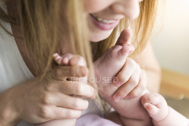 Close up of mother holding baby feet — Stock Photo