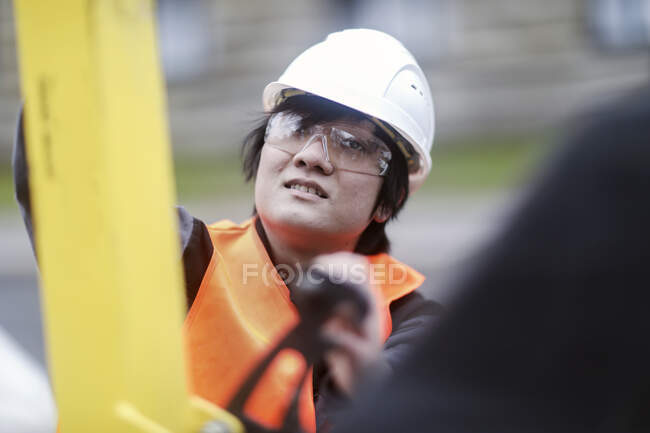 Jovem trabalhador da construção usando chapéu duro — Fotografia de Stock