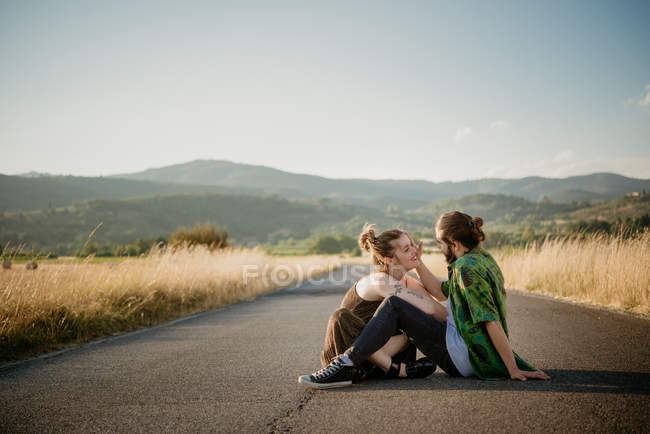 Couple sitting on rural road, Arezzo, Tuscany, Italy — Stock Photo