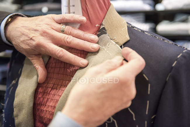Schneiderin bereitet maßgeschneiderte Anzugjacke auf Schneiderattrappe vor — Stockfoto