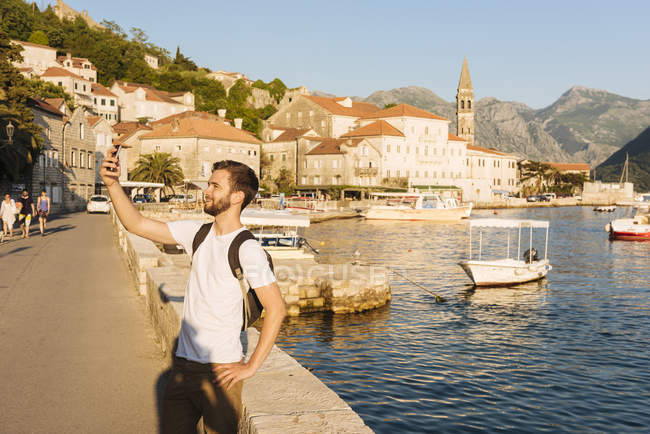 Uomo in porto a scattare selfie in Perast, Montenegro, Europa — Foto stock