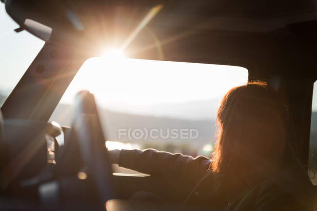 Femme regardant par la fenêtre de la voiture — Photo de stock