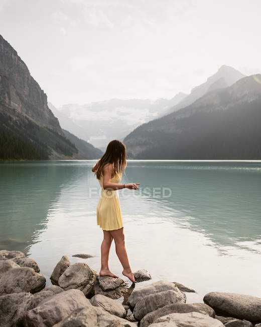Femme en robe jaune par Lake Louise, Canada — Photo de stock