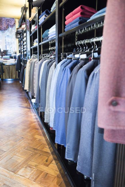Rows of suit jackets hanging in traditional tailors shop — Stock Photo