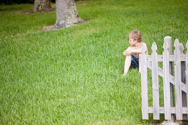 Хлопчик сидить на зеленій траві — стокове фото