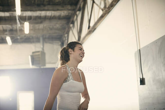 Портрет жінки в спортзалі дивиться вбік посміхаючись — стокове фото