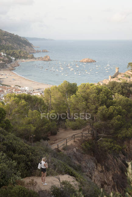 Donna in piedi sulla roccia, guardando la vista, vista elevata, Tossa de mar, Catalogna, Spagna — Foto stock
