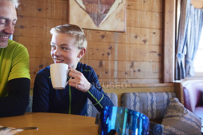 Père et fils faisant une pause café dans une cabane en rondins, Hintertux, Tyrol, Autriche — Photo de stock