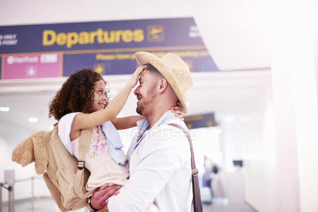 Padre e hija abrazándose en la sala de salida del aeropuerto - foto de stock