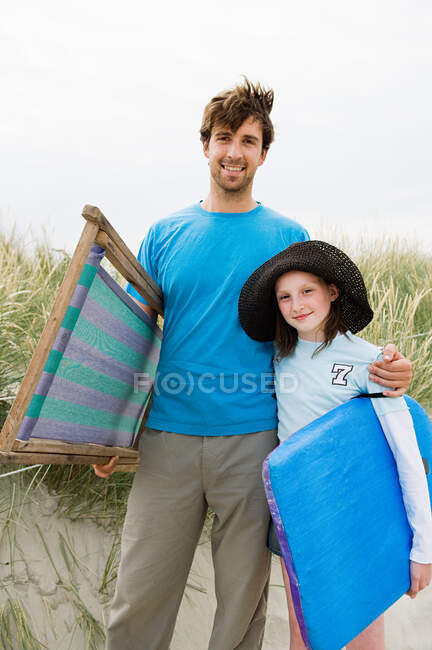 Joven en la playa con hija, retrato - foto de stock