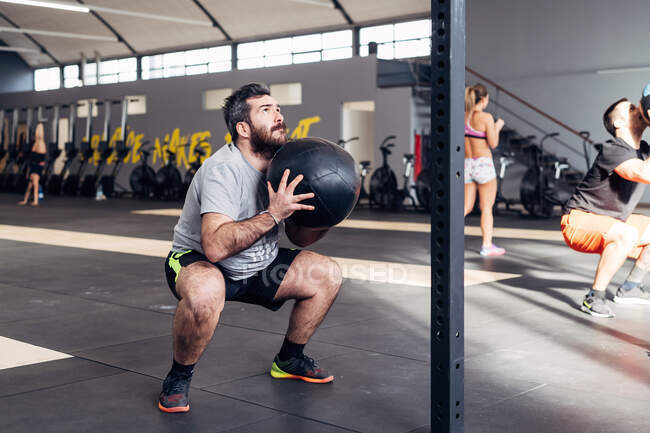 Homme dans la salle de gym utilisant la médecine ball — Photo de stock