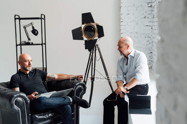 Male colleagues talking in creative studio — Stock Photo