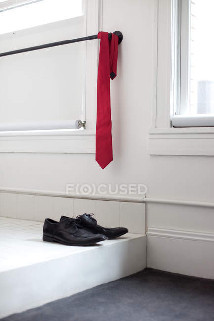 Червона краватка і пара взуття вдома — стокове фото