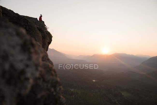Mujer en la cima de la colina al amanecer, Rattlesnake Ledge, Washington, EE.UU. - foto de stock