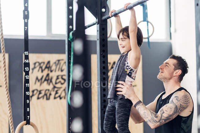 Батько і дочка використовують тягнути бар в спортзалі — стокове фото
