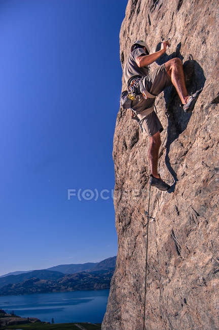 Visão de baixo ângulo do homem escalando em Skaha Bluffs no Parque Provincial, Penticton, Canadá — Fotografia de Stock
