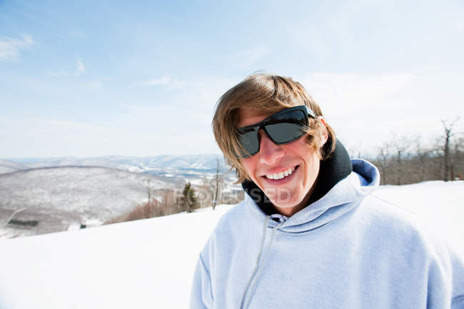 Retrato de jovem em óculos de sol sorrindo para a câmera — Fotografia de Stock