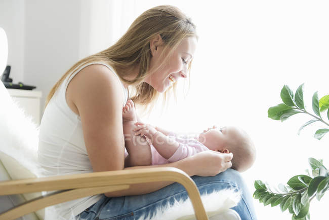 Side view of mother and baby on chair — Stock Photo