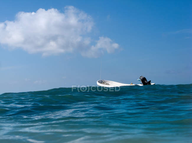 Barca vuota nell'oceano con cielo blu con nuvole — Foto stock