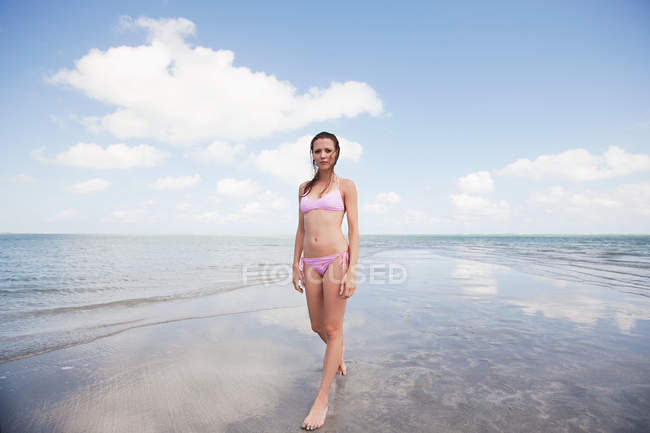 Junge Frau steht im seichten Meer — Stockfoto