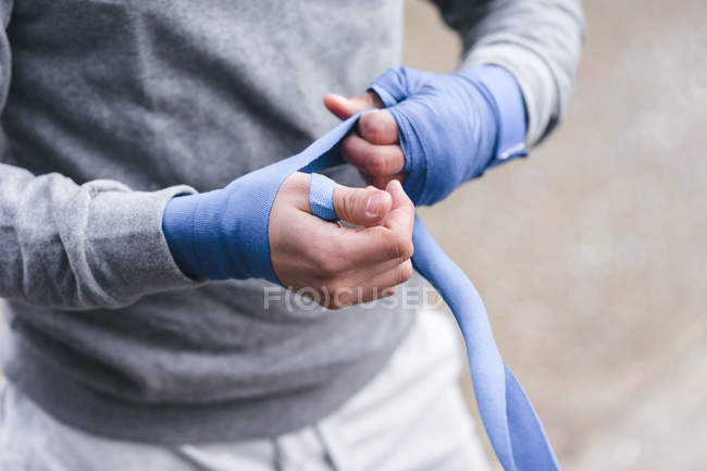 Male boxer bandaging hands with hand wraps — Stock Photo