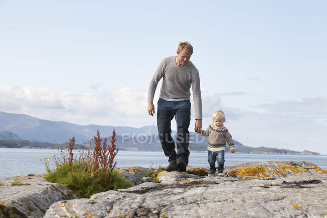 Homem e filho criança passeando por fiorde, Aure, Mais og Romsdal, Noruega — Fotografia de Stock