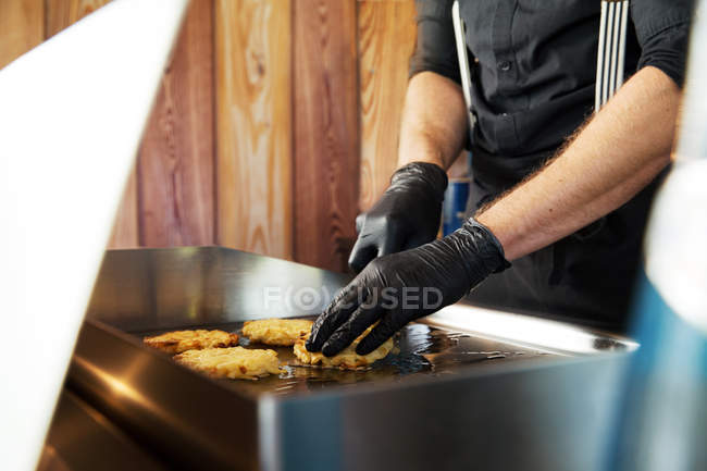Cropped image of chef preparing food on flat top grill — Stock Photo
