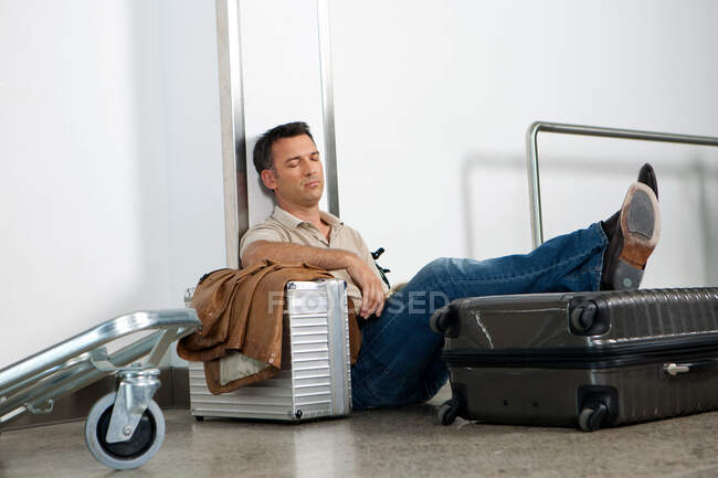 Caucasiano cansado Homem dormindo na bagagem no aeroporto — Fotografia de Stock
