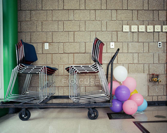 Стільці і повітряні кулі, розміщені на стіні в приміщенні — стокове фото