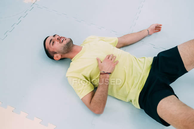 Homem exausto deitado no chão nas costas — Fotografia de Stock