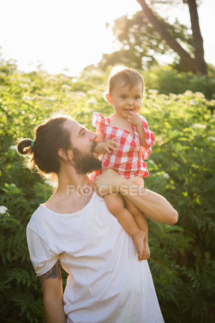 Portrait of man with baby girl in garden — Stock Photo