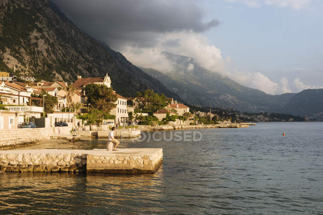 Giovane seduto sul molo di Kotor, Montenegro, Europa — Foto stock