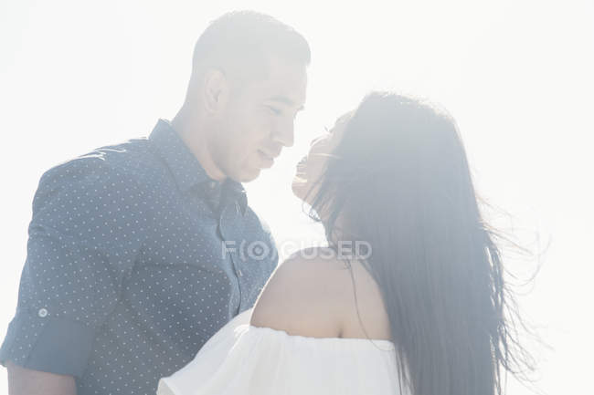 Couple outdoors, face to face, gazing into each others eyes — Stock Photo