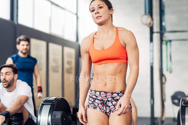 Woman in gym wearing lycra crop top and shorts — Stock Photo