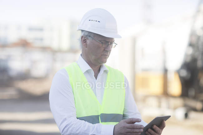 Travailleur de la construction adulte utilisant une tablette numérique — Photo de stock