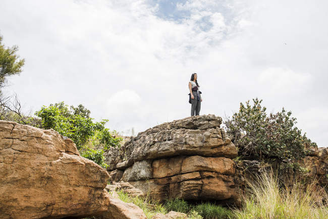 Vista a distanza di Giovane turista donna guardando fuori dalla roccia a Bourkes Potholes, Mpumalanga, Sud Africa — Foto stock