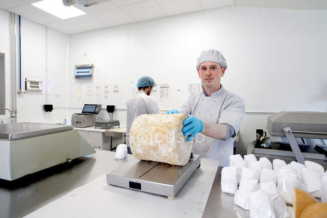 Portrait of cheese maker about to cut a large wheel of stilton — Stock Photo