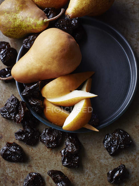 Still life with fresh pears and prunes, overhead view — Stock Photo