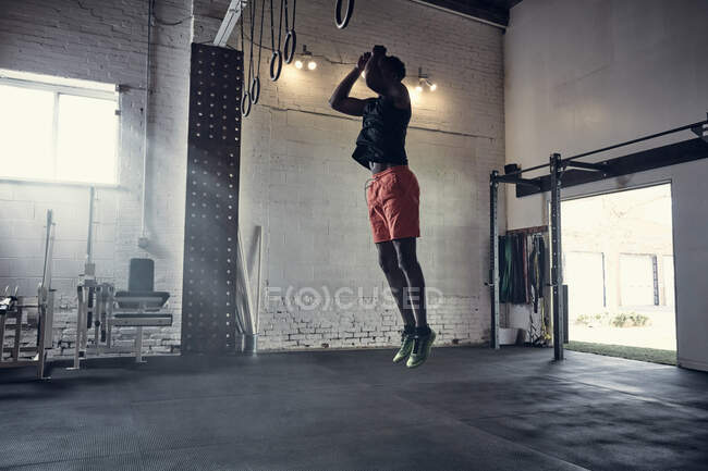 Чоловік в спортзалі стрибає в повітрі — стокове фото
