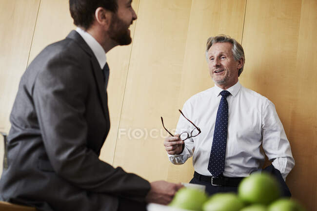 Due uomini d'affari in chat in ufficio — Foto stock