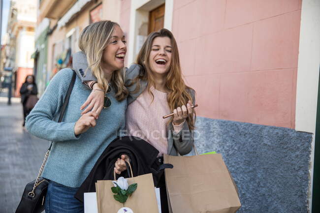 Friends out shopping and laughing in street — Stock Photo