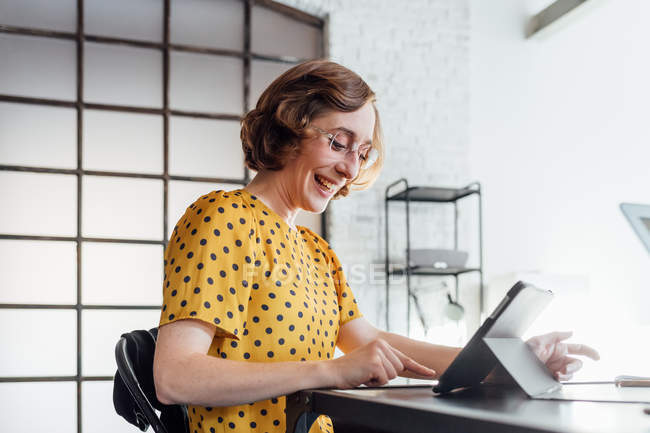 Femme d'affaires utilisant une tablette numérique et souriant — Photo de stock