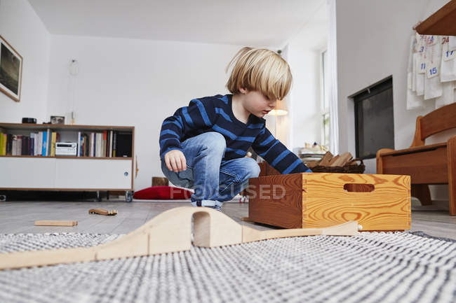 Jeune garçon jouant avec des jouets dans le salon — Photo de stock