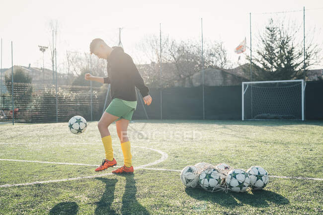 Jogador de futebol praticando em campo de futebol — Fotografia de Stock